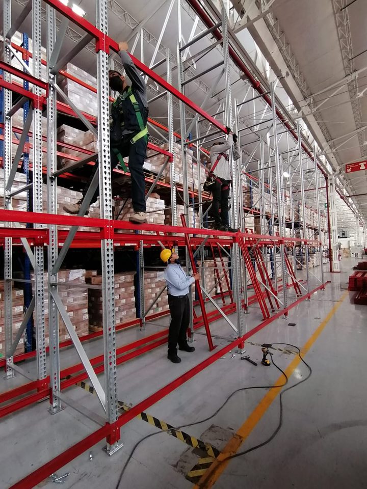 Cuadrilla de Racks Solutions México instalando racks industriales con arnés de seguridad