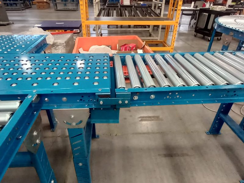 Transportador de rodillos con módulo de transferencia en planta industrial